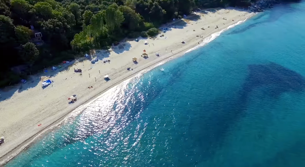 The beaches of Agioi Saranta and Horefto a natural theater of contrasts between green slopes and deep blue waters